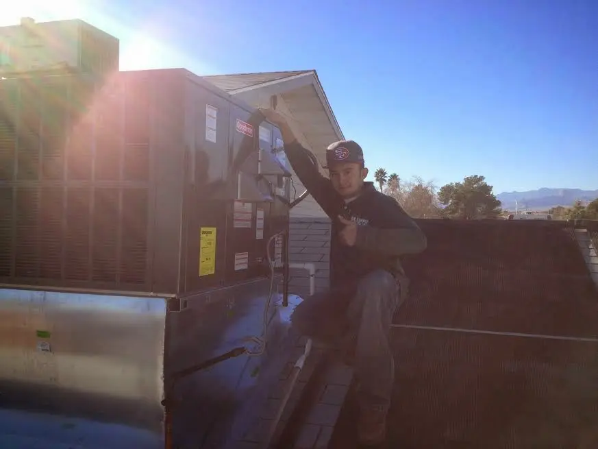 HVAC technician performing Boiler Repair on a rooftop unit in Bull Mountain